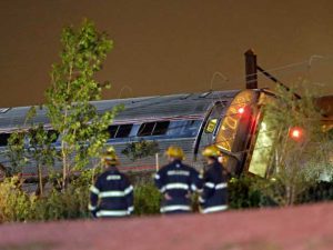 Bombeiros observam vagão tombado de um trem Amtrack que descarrilou na Filadélfia. (Foto: Matt Slocum / AP Photo)